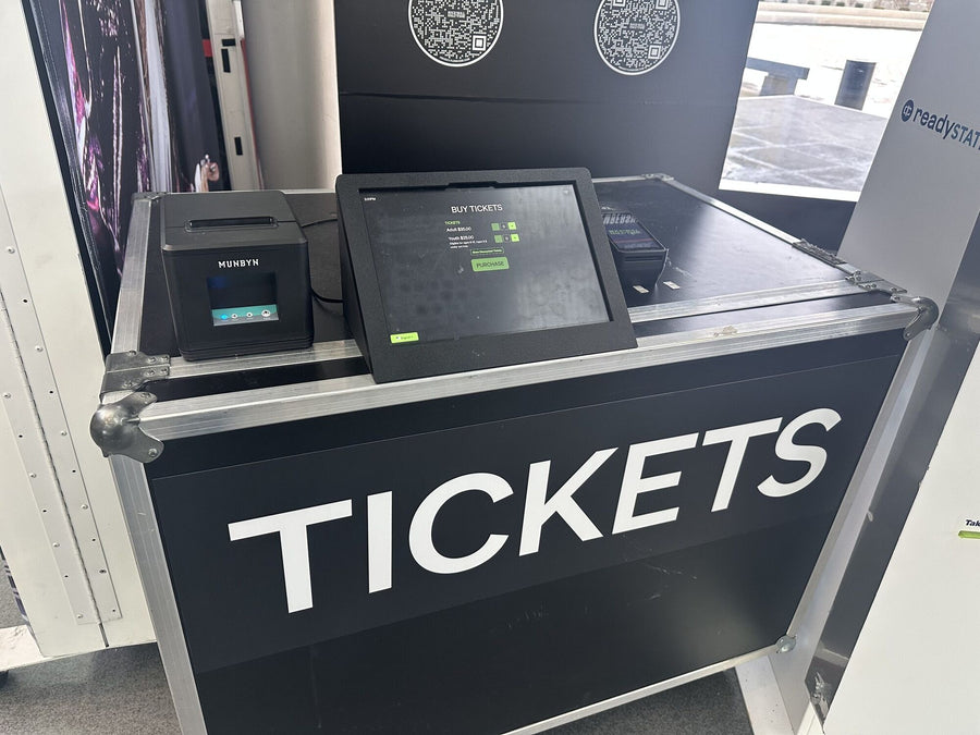 Self-service ticketing kiosk built into a road case, with a touchscreen, receipt printer, and scanner